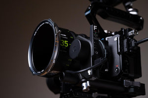 Close-up of a professional camera with lens and control panel on a dark background