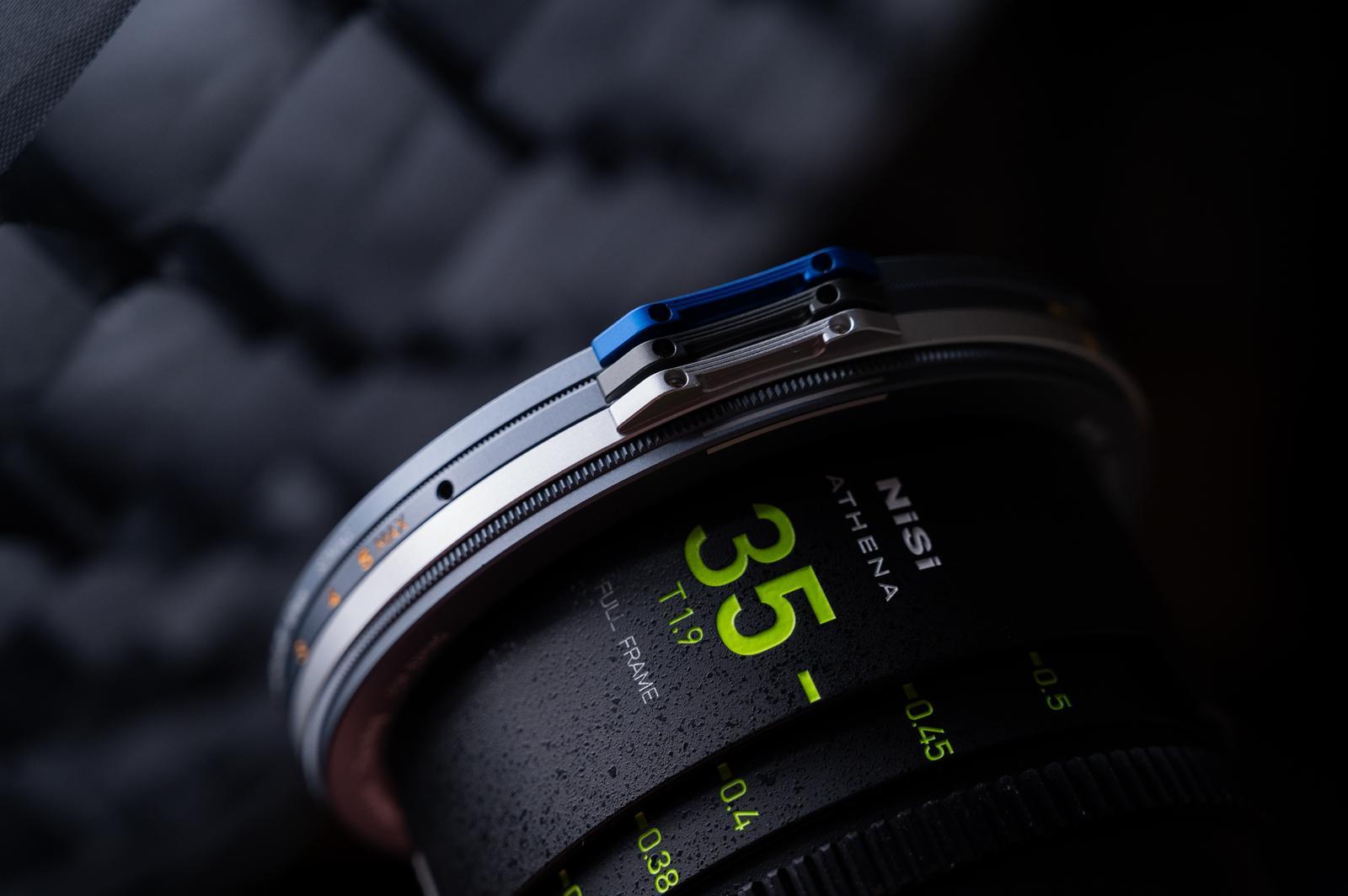Camera lens with focus scale and brand name on a dark background