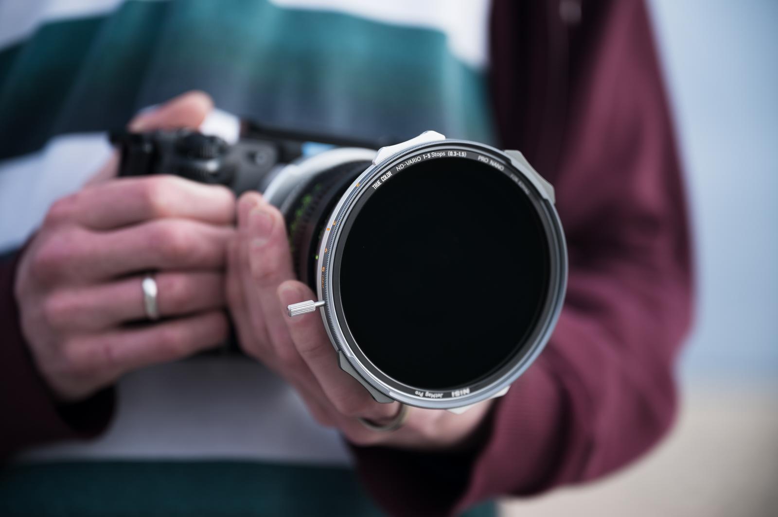 Person holding a camera with a large lens