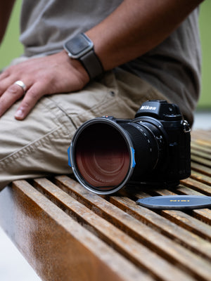 Nisi JetMag Pro Filtru Medium FS GND8 (0.9) 82mm. Nikon camera on a wooden bench with a person's hand and watch in the background