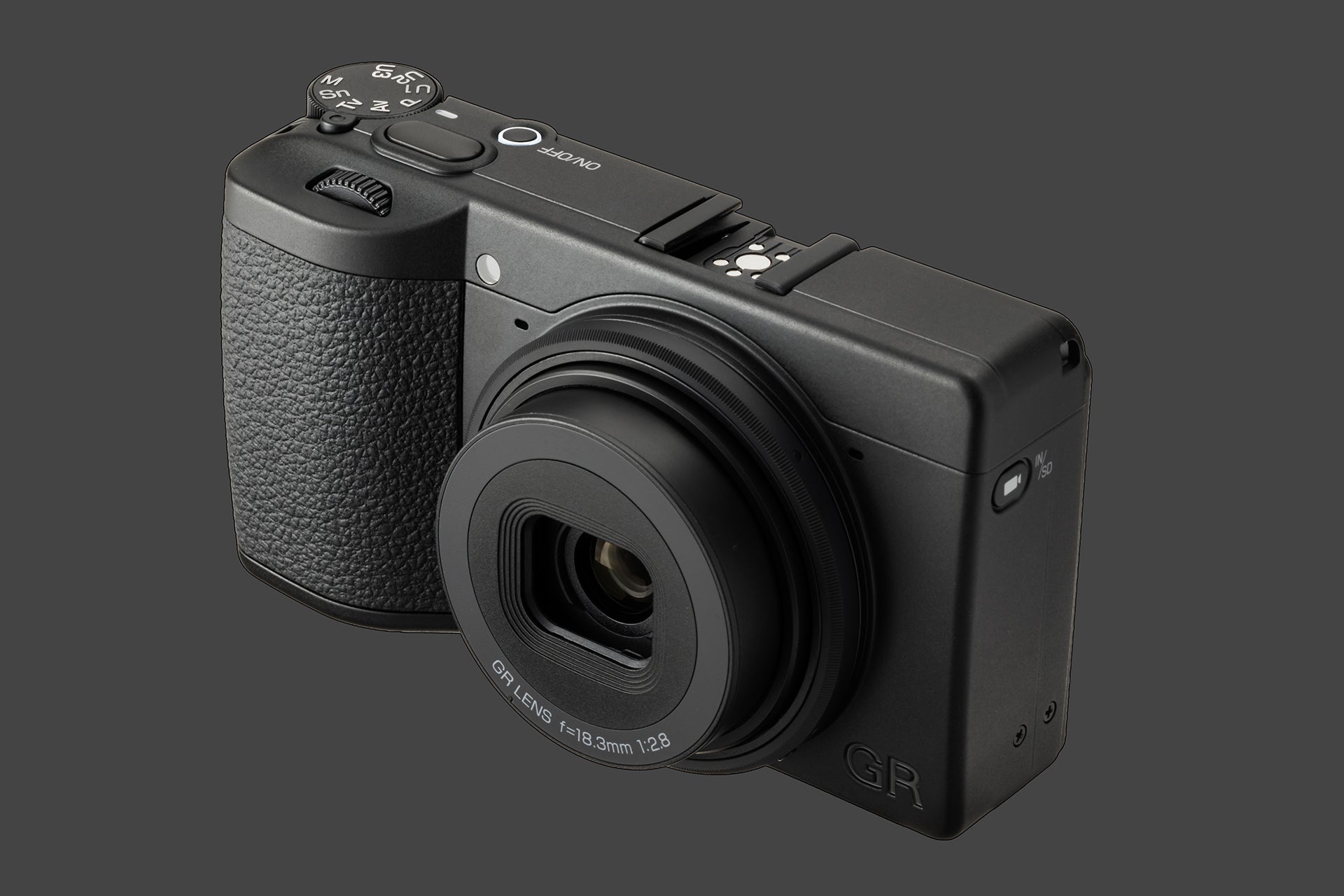 Vedere de sus a aparatului Ricoh GR IV Monochrom, prezentând rotița de selecție a modurilor, butonul de pornire și patina pentru accesorii pe un corp compact negru.