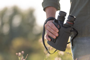 Binoclu cu stabilizare Kite Optics APC 42 12x42 AA ținut în mână în timpul unei activități în aer liber