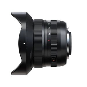 Obiectiv ultra-wide Fujifilm XF 8mm f/3.5 R WR cu parasolar montat, vedere laterală pe fundal alb.