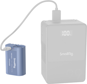 Acumulator albastru SmallRig DMW-BLK22 fiind încărcat de la un power bank extern SmallRig cu afișaj digital.
