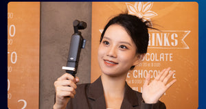 Woman holding a camera stabilizer in front of an orange background with text