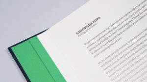 Detaliu din interiorul albumului „Cuejdel” deschis la pagina intitulată „Photographer’s note” semnată de Gheorghe Popa. Textul începe cu o reflecție despre liniștea profundă a lacului și experiența personală în sălbăticia Munților Carpați. Designul paginii păstrează inserția de hârtie verde smarald, oferind o estetică elegantă și unitară întregului volum.