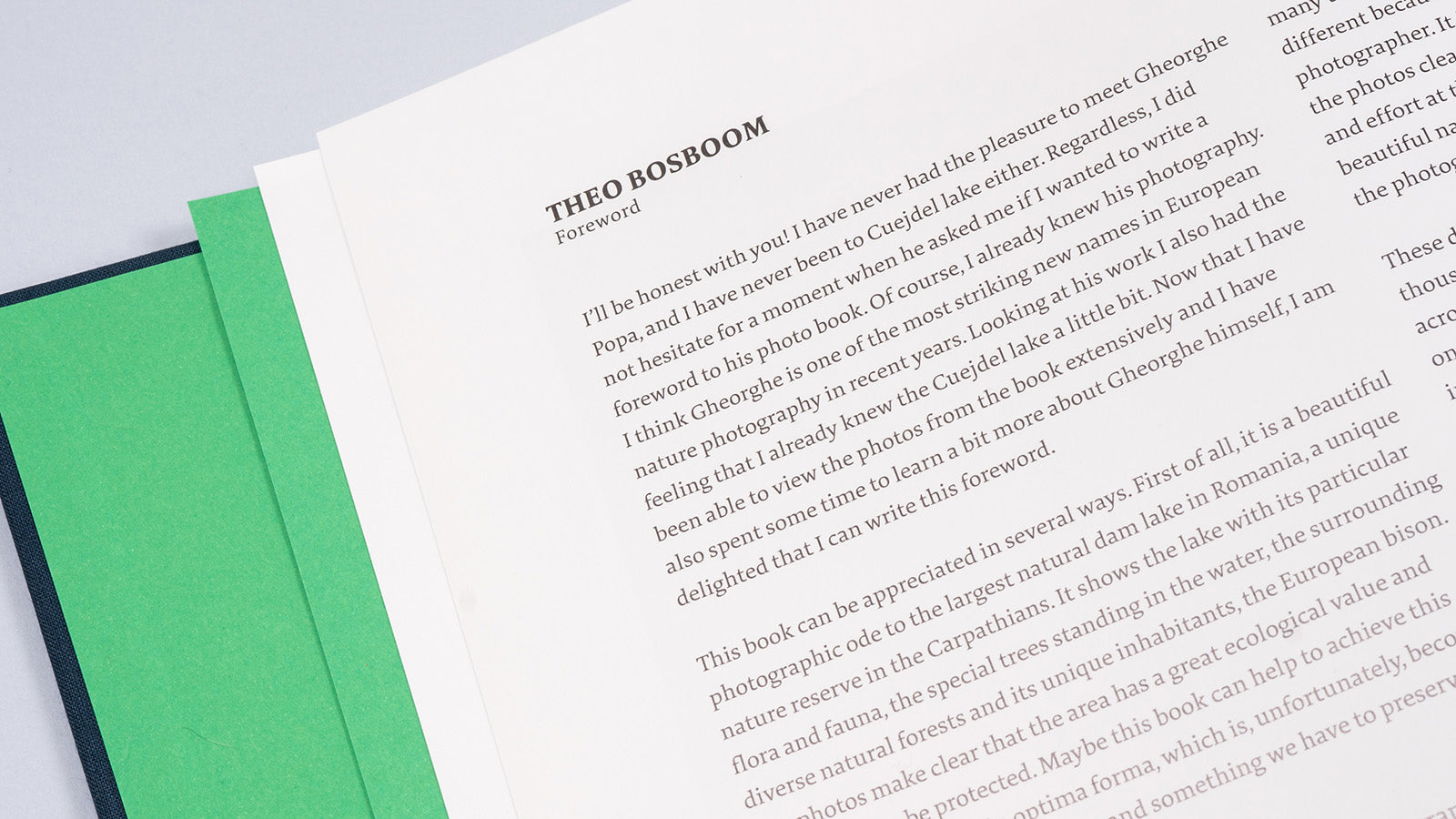 Detaliu cu primele pagini ale albumului „Cuejdel”, deschis la secțiunea „Foreword” semnată de fotograful Theo Bosboom. Textul în limba engleză descrie valoarea fotografică a lacului Cuejdel și aprecierea pentru munca lui Gheorghe Popa. În partea stângă se observă un insert de hărtie verde, adăugând un accent vizual deosebit designului interior.