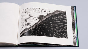 Albumul foto de artă deschis la o pagină ce prezintă fotografia multipremiată internațional a lui Gheorghe Popa, intitulată „Yin and Yang”. Imaginea este o compoziție monocromă fine art, realizată dintr-o perspectivă aeriană a lacului Cuejdel. Ea surprinde un contrast puternic între o zonă deschisă la culoare (gheață sau apă limpede) populată de trunchiuri de copaci scufundați și o zonă întunecată (pădure sau reflexie adâncă) cu forme similare, creând o metaforă vizuală puternică a dualității și echilib